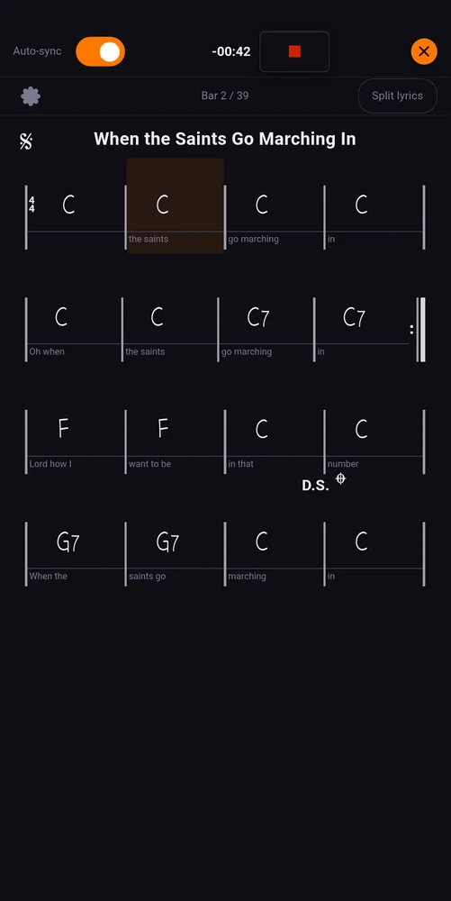 A chord chart on stage, the words written under the bars they are sung over
